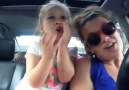Arabada sevimli sevimli şarkı söyleyen anne ve kız