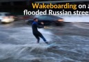 A wakeboarder zips through flooded Russian street