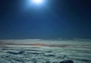 Ay ışığı altında seyir eden bir yolcu uçağının kokpitinden