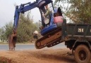 Excavator climbing onto Truck