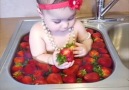 Just an adorable baby in bath of strawberries Credit JukinVideo