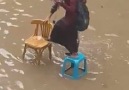 Man helps women cross a flooded street