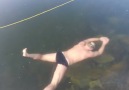 This free diver is swimming under incredibly clear ice!