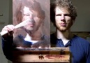 This guy is painting a portrait of himself by looking in the mirror